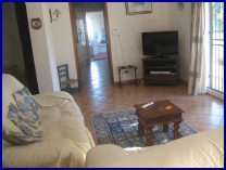 spacious living area showing door through to kitchen and comfortable settee with french windows